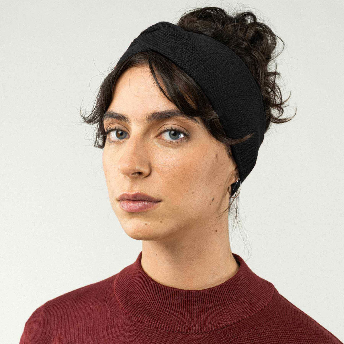 Frau trägt schwarzes Stirnband gestrickt und gedreht